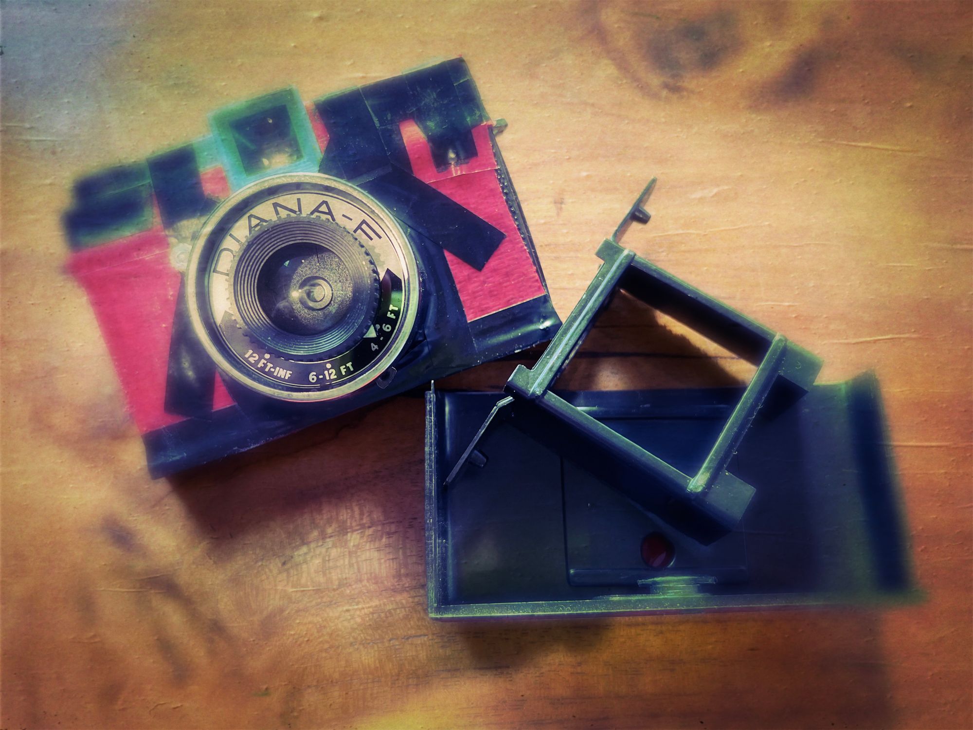 faux vintage photo of a Diana-F camera that is in pieces. the body is covered with electrician's tape