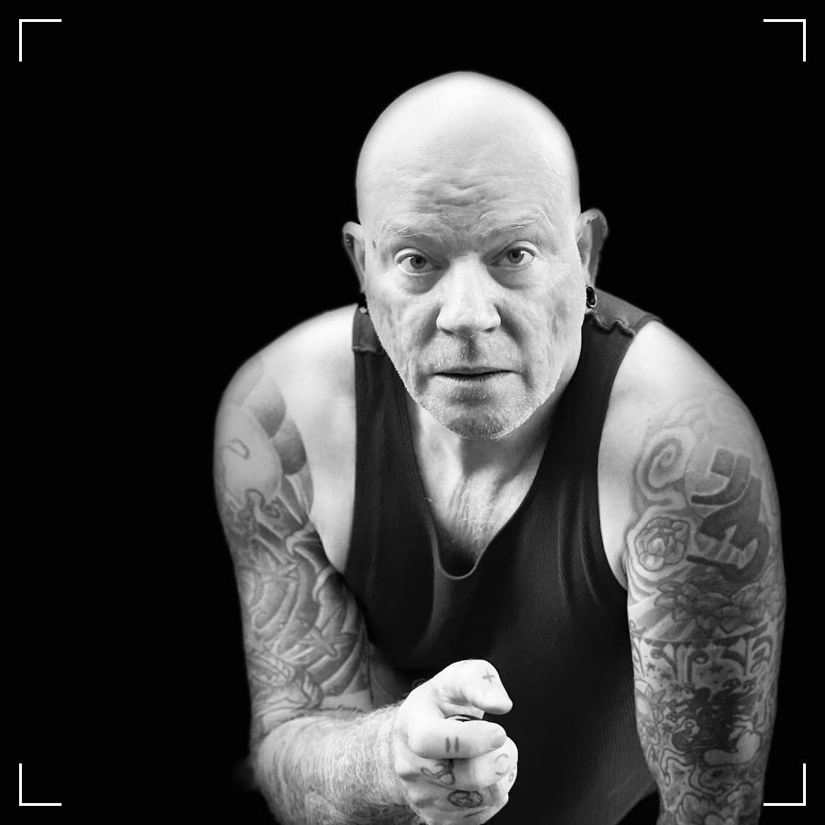 black and white photo of a middle aged bald, white guy looking at the viewer